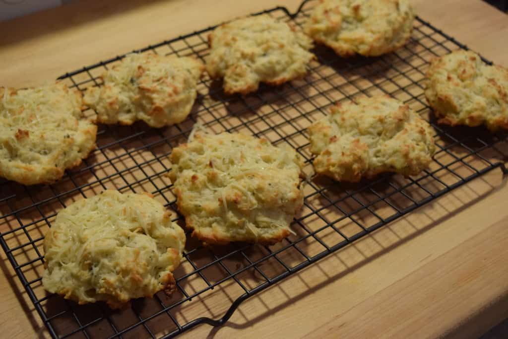 Freshly baked buttermilk drop biscuits on a cooling rack.