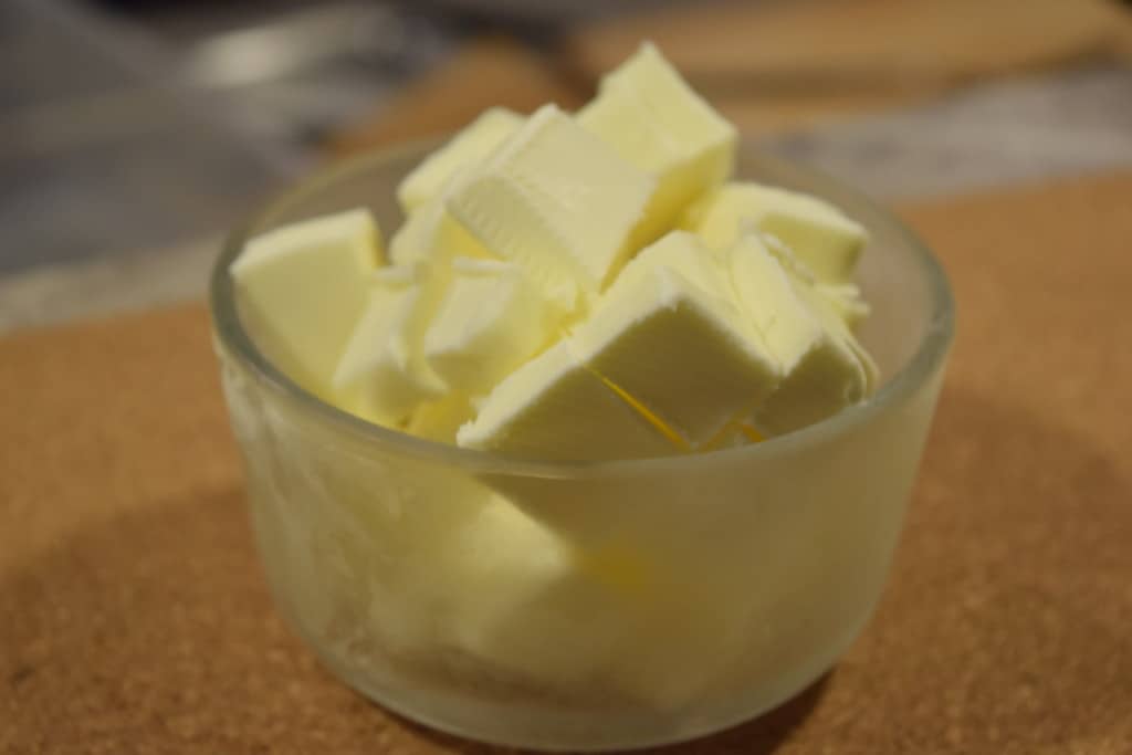 Diced frozen butter in a glass container.