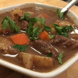 Season flour with salt and pepper. Lightly coat meat with flour mixture. Heat olive oil in large pot. Brown meat over medium-high heat, in multiple rounds, careful not to overcrowd the pan. Once you've browned all the beef, add it all into the pot together. Add garlic to the pot with the beef and saute for about 30 seconds or until fragrant. Add the beef stock, water, beer, red wine, tomato paste, sugar, thyme, Worcestershire sauce, and bay leaves. Stir to combine. Bring the mixture to a simmer. Reduce the heat to low, cover and cook for about an hour. Check on it every 15 minutes or so and stir. In a separate medium sized pot, melt the butter. Add the onions and carrots. Saute for about 15 minutes until they are soft and golden. Set aside. After an hour, add the onions, carrots and potatoes to the stew. Season with salt and pepper. Simmer uncovered until veggies and beef are nice and tender, about 45-50 minutes. Discard the bay leaves (don't forget this!). Tilt the pan and spoon off any visible fat off the top layer of the stew. Transfer the stew to a bowl, season with salt and pepper, top with fresh parsley, grab some crusty bread and enjoy.