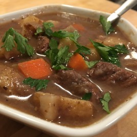 Season flour with salt and pepper. Lightly coat meat with flour mixture. Heat olive oil in large pot. Brown meat over medium-high heat, in multiple rounds, careful not to overcrowd the pan. Once you've browned all the beef, add it all into the pot together. Add garlic to the pot with the beef and saute for about 30 seconds or until fragrant. Add the beef stock, water, beer, red wine, tomato paste, sugar, thyme, Worcestershire sauce, and bay leaves. Stir to combine. Bring the mixture to a simmer. Reduce the heat to low, cover and cook for about an hour. Check on it every 15 minutes or so and stir. In a separate medium sized pot, melt the butter. Add the onions and carrots. Saute for about 15 minutes until they are soft and golden. Set aside. After an hour, add the onions, carrots and potatoes to the stew. Season with salt and pepper. Simmer uncovered until veggies and beef are nice and tender, about 45-50 minutes. Discard the bay leaves (don't forget this!). Tilt the pan and spoon off any visible fat off the top layer of the stew. Transfer the stew to a bowl, season with salt and pepper, top with fresh parsley, grab some crusty bread and enjoy.