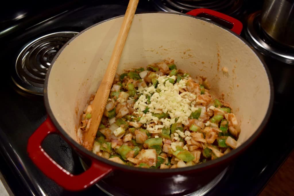 Adding veggies to roux for cajun chicken stew. 