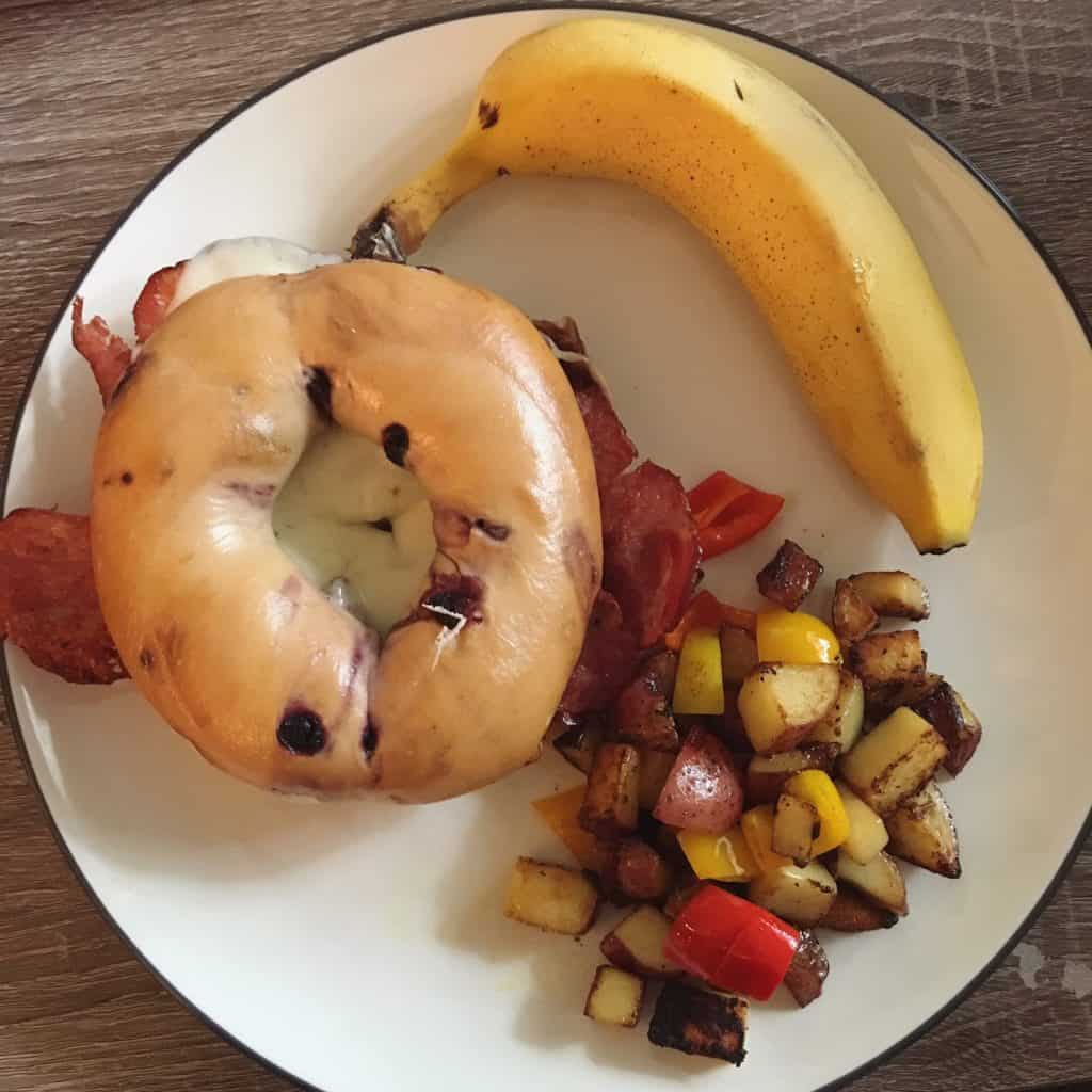 Blueberry bagel with turkey bacon and fried egg.