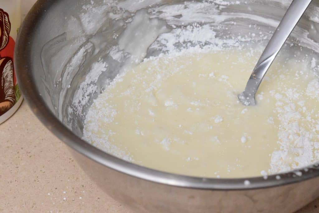 Mixing bowl with yogurt and powdered sugar.