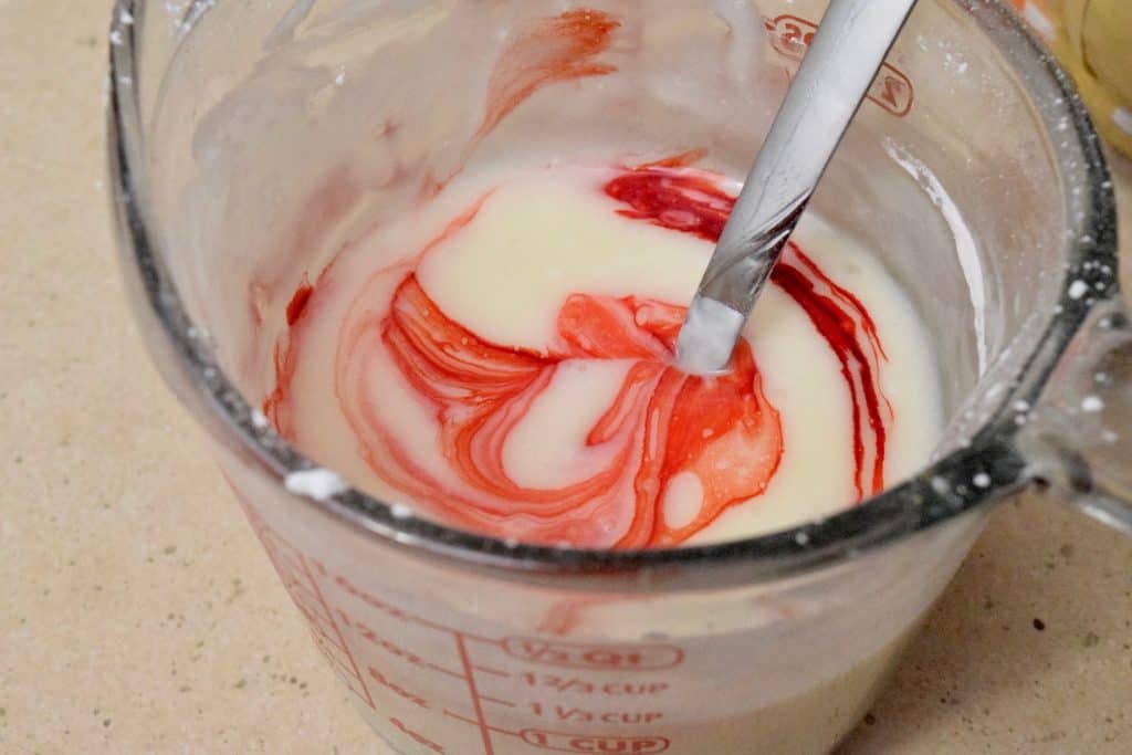 Stirring food coloring into yogurt mixture.