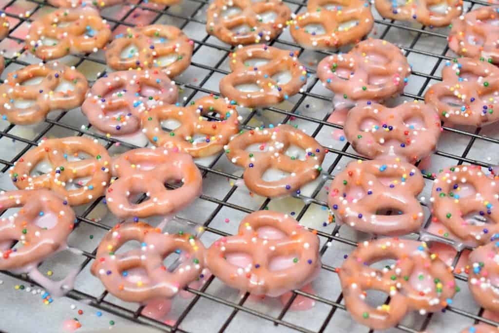 Topping yogurt covered pretzels with sprinkles.