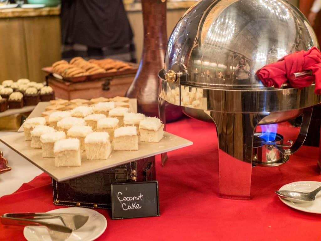 Coconut cake at The Barn on the brunch buffet dessert table with a red tablecloth.