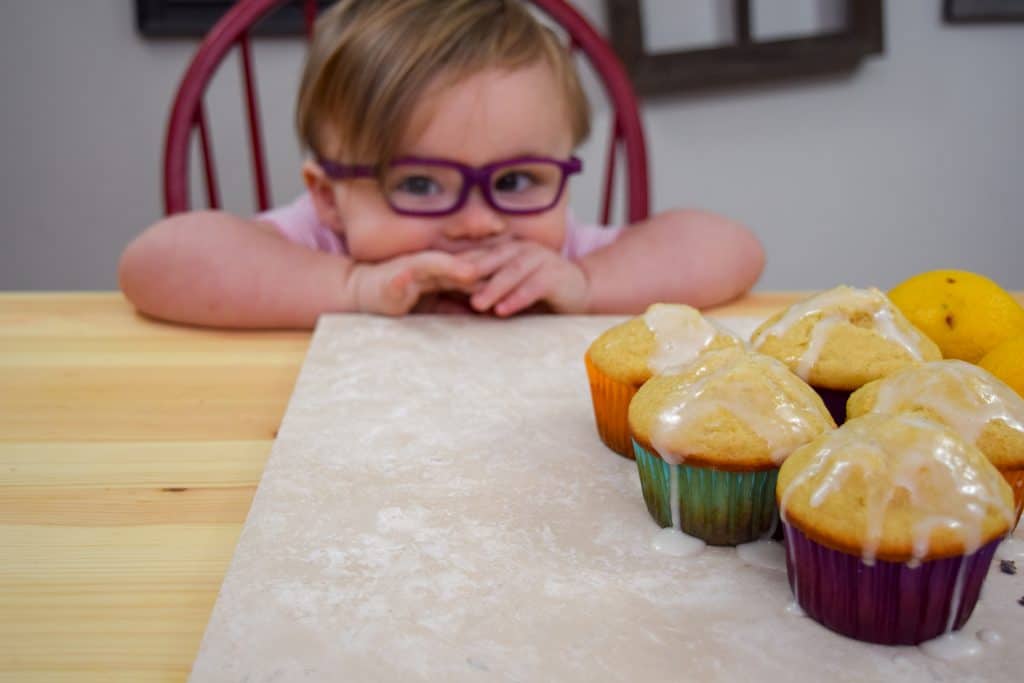 Cute kiddo with Bright and Citrusy Lavender Lemon Muffins with lemon glaze.