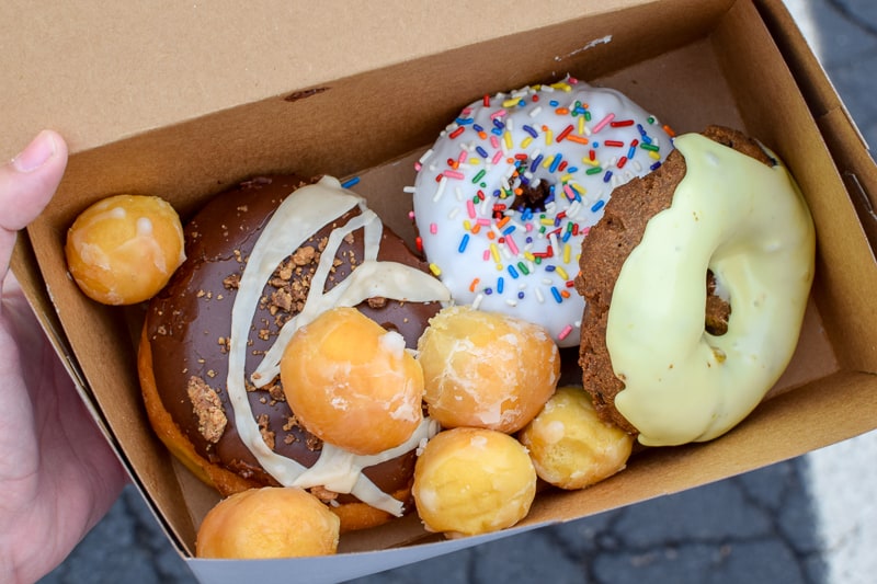 Assorted donuts in a box from Mimi's Donuts & Bakery.