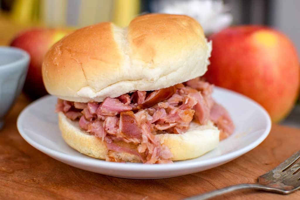 This homemade smoked turkey sandwich is topped with a delicious tangy and spicy apple bbq sauce. The sandwich is made with smoked turkey drumsticks, chopped and tossed on a soft bun. For extra deliciousness, serve with white cheddar cheese and fresh jalapenos. 