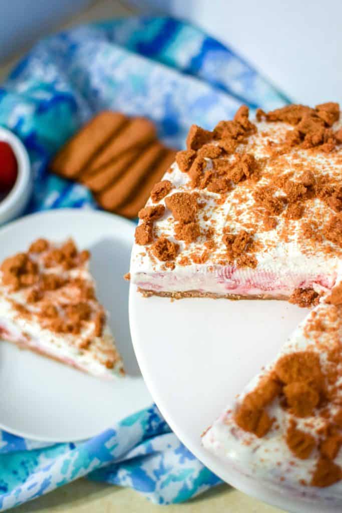 Strawberry Ice Cream Cake on a white serving dish with a slice missing.