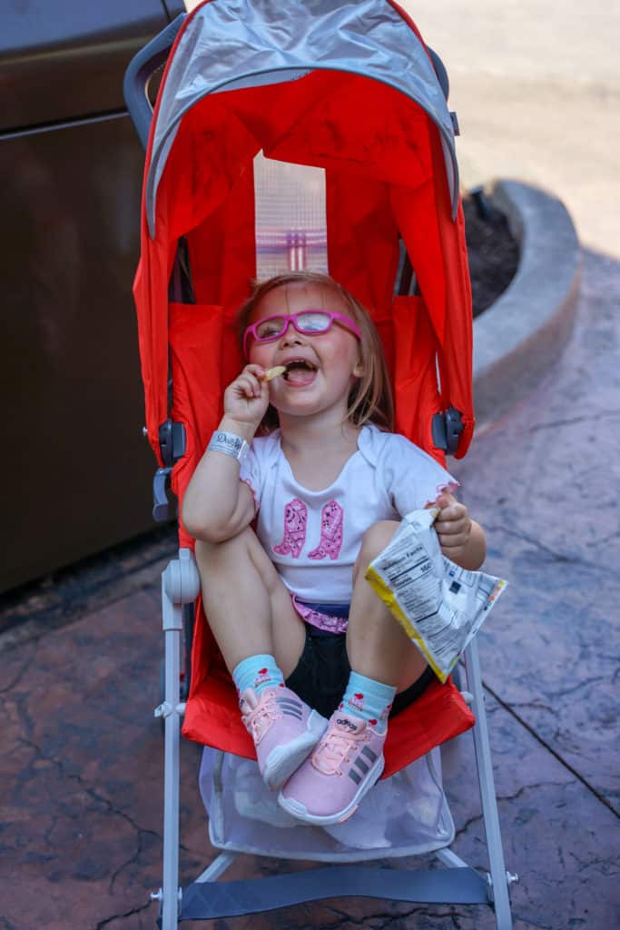 Child eating snacks in a stroller during a visit at Dollywood.