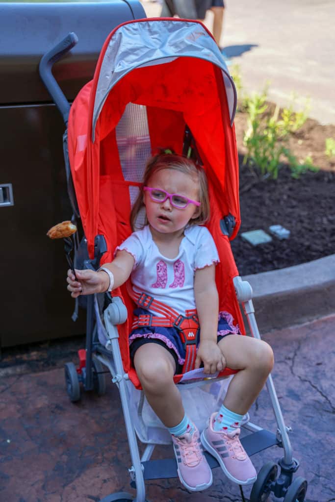 Daughter eating food in stroller.