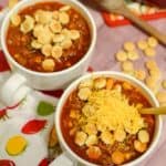 Two bowls of homemade no bean chili topped with oyster crackers and shredded cheese.