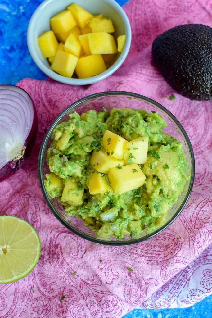Homemade guacamole is the best! But, to make it even better - top with freshly chopped mango to make a mango guacamole to enjoy alone with chips or on tacos!