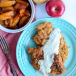 These perfect pan fried pork chops are topped with a easy to make homemade white gravy that's made with apples! This recipe will help you learn how to fry pork chops to perfection.