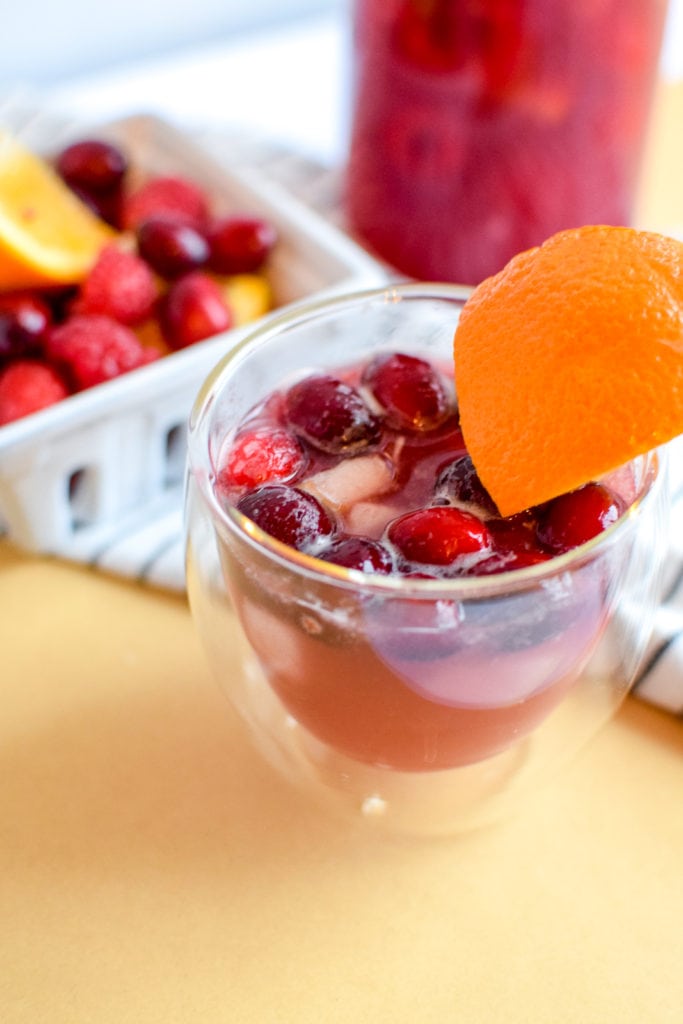 This winter sangria mocktail recipe is incredibly simple to make, absolutely delicious, and filled with fruit like pears, cranberries, oranges, and raspberries! It's perfect for a small crowd or just for one.