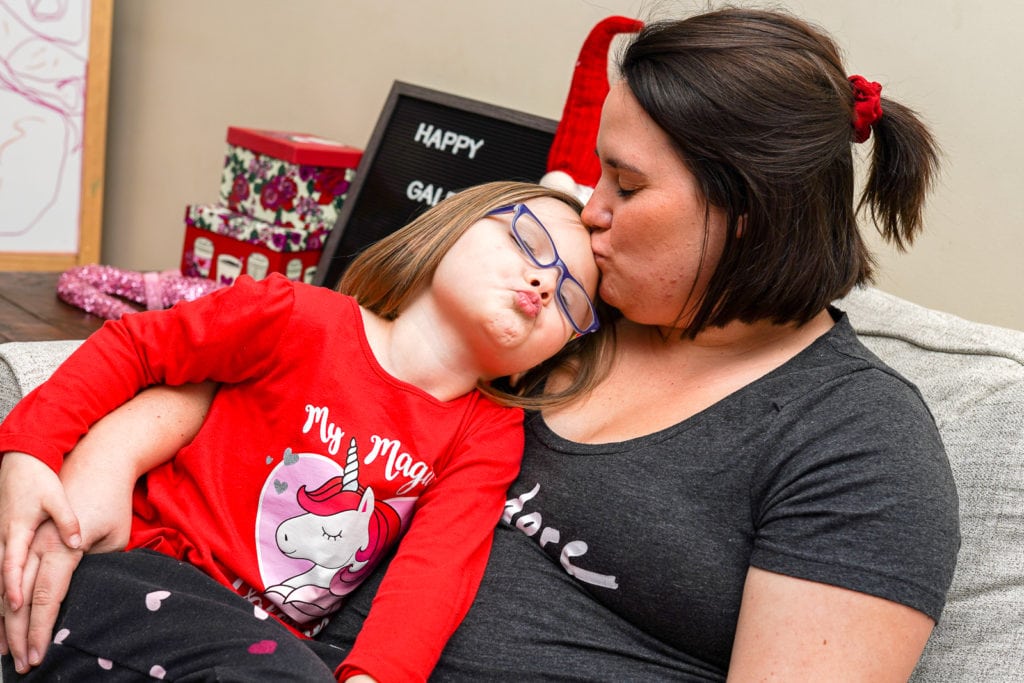 Mother kissing daughter.