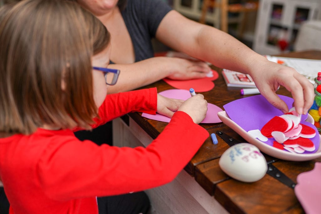 Kid doing craft for valentine's day.