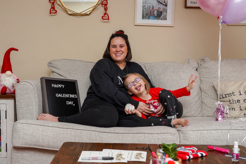 Mother and daughter on couch during valentine's day party.