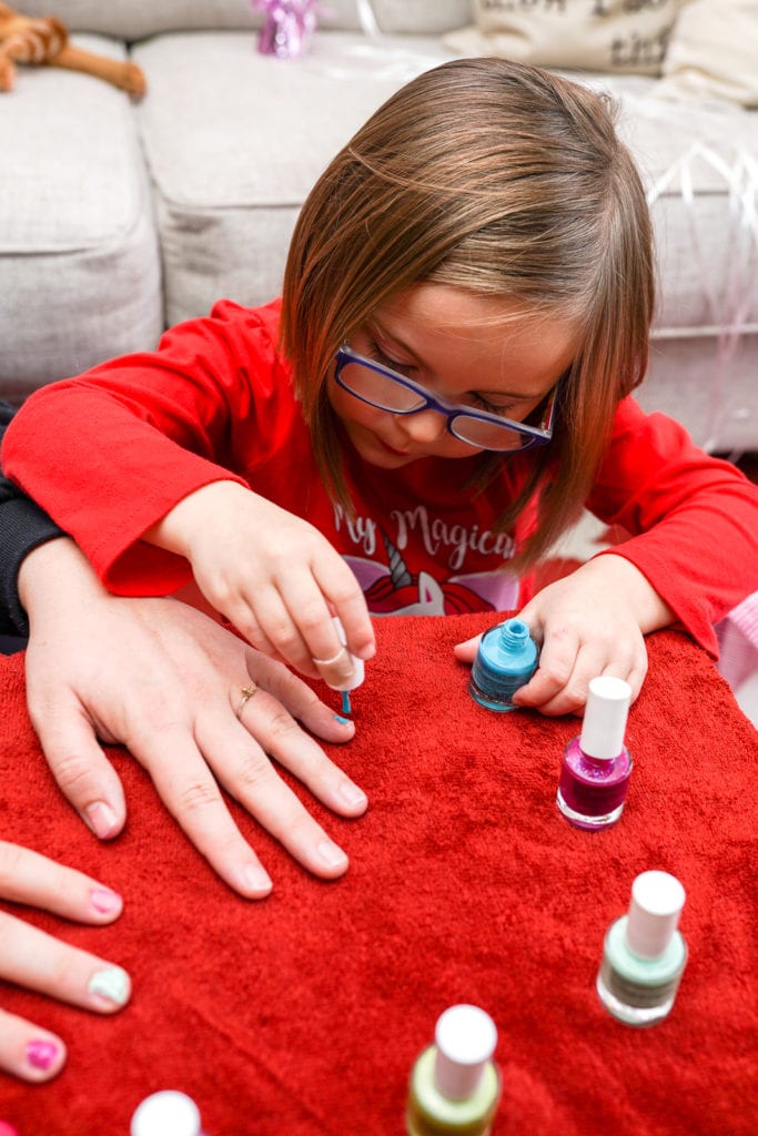 Child painting mom's nails.