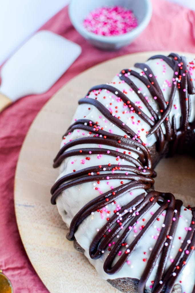 Half of chocolate bundt cake on a serving platter.