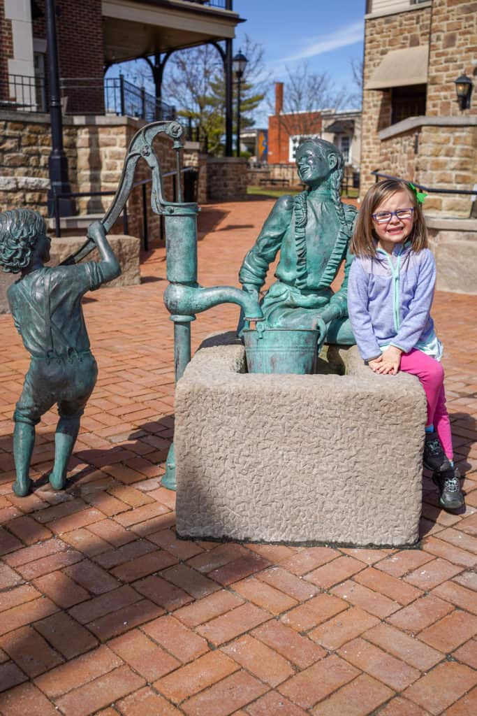 Child sitting on sculpture in downtown Dublin, Ohio.