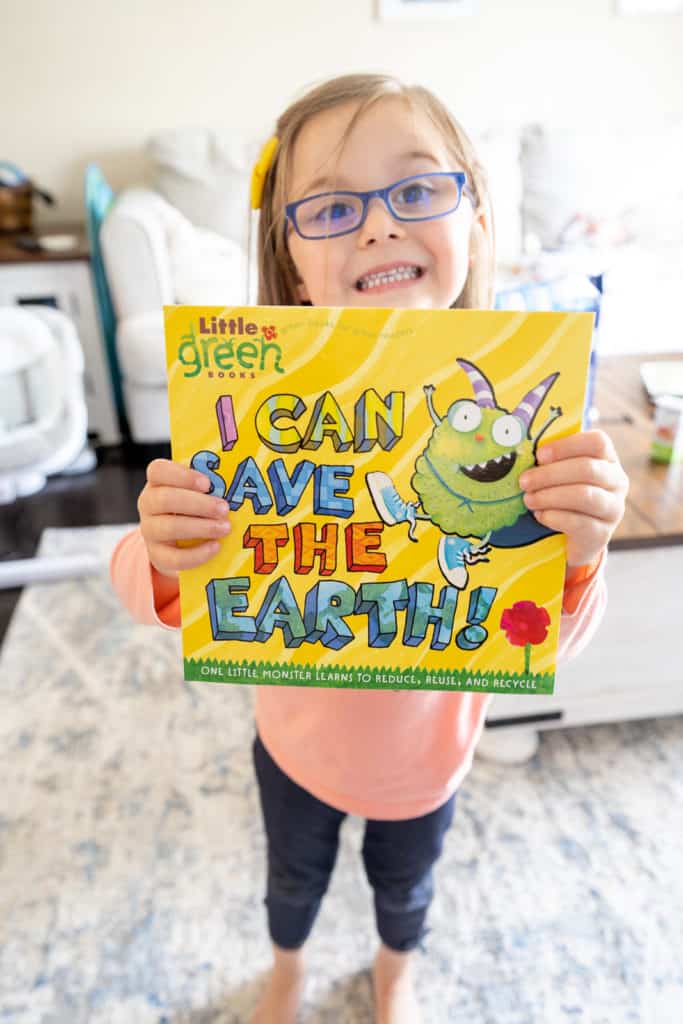 Children holding up book that is about earth day.