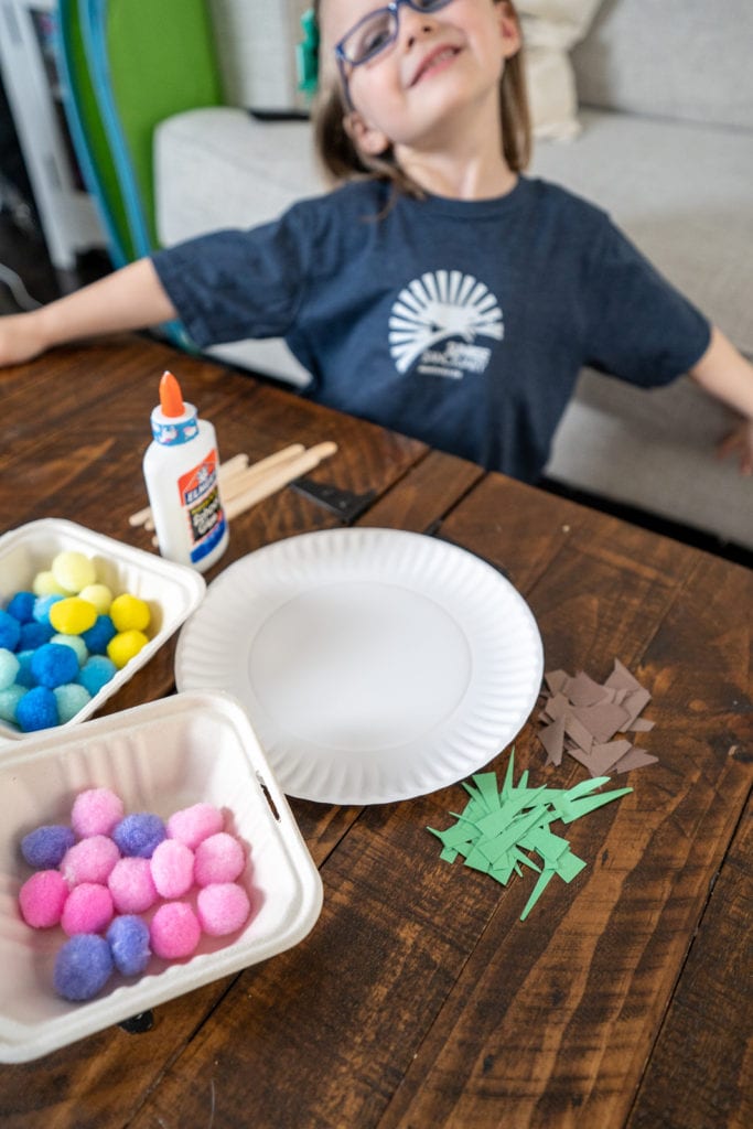 Child beginning earth day paper plate craft activity.