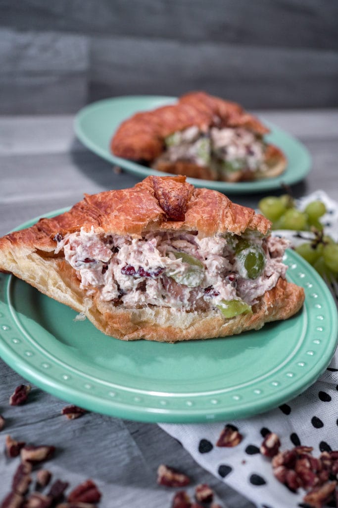 Overflowing chicken salad sandwich made with a butter croissant.