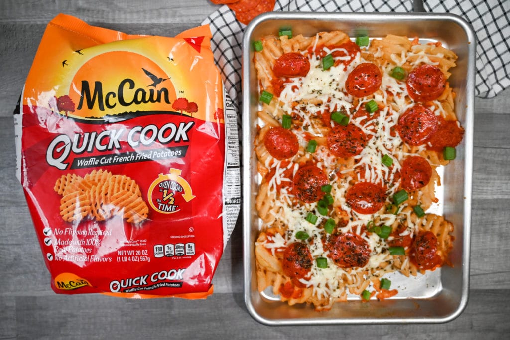 Pizza Fries on a sheet pan next to a bag of McCain foods quick cook waffle fries.