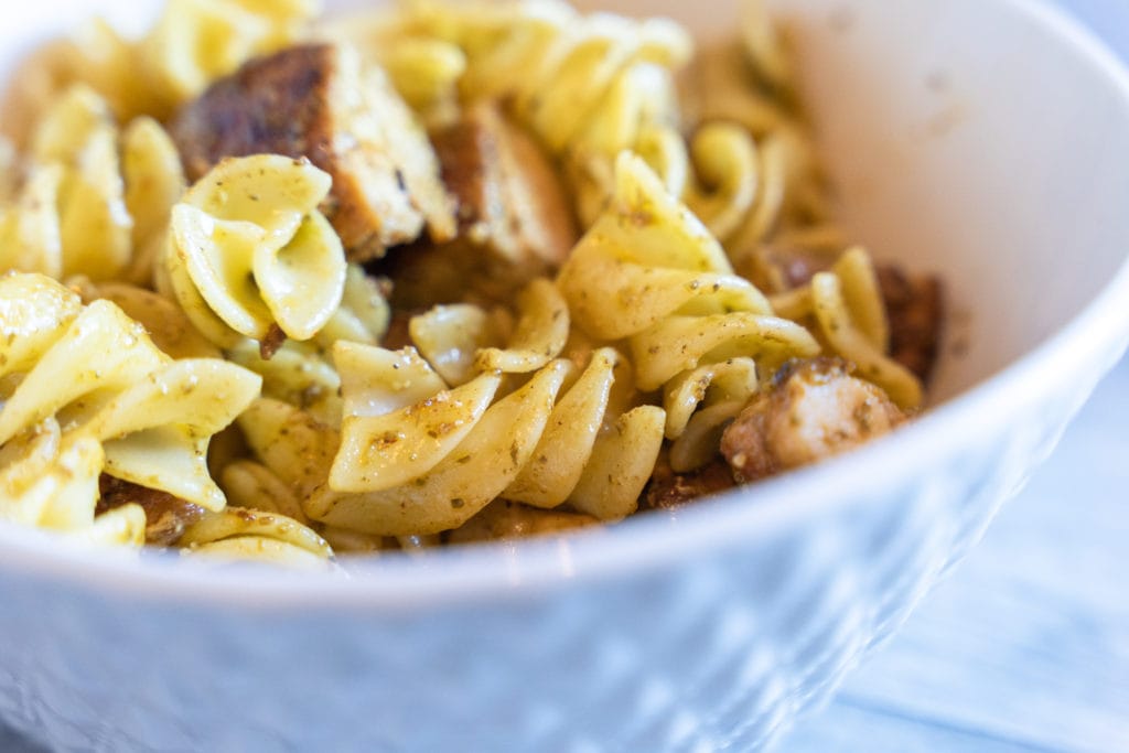 Pesto Genovese sauce over rotini noodles in bowl.