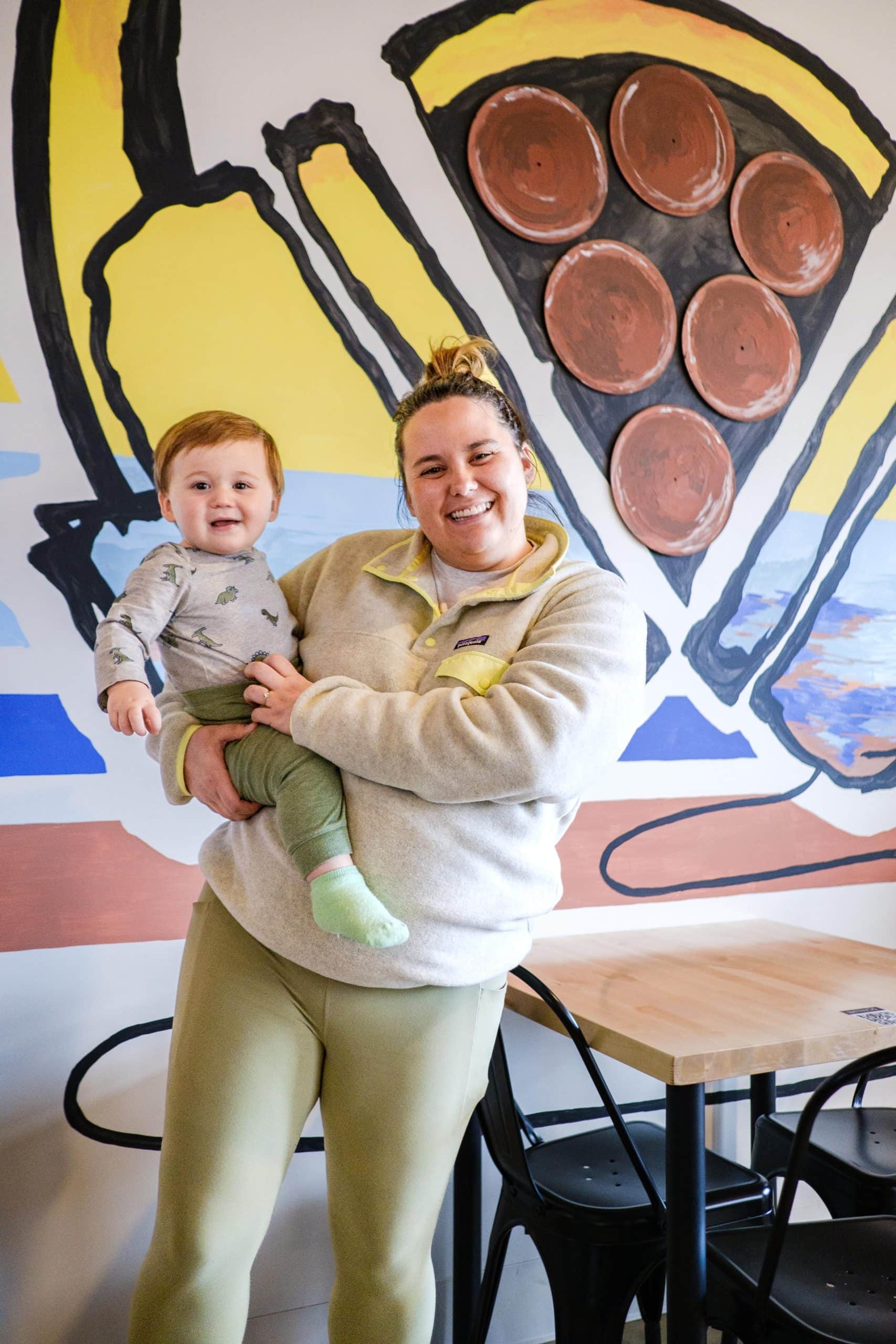 Mother and son posing in front of pizza mural at Sexton's Pizza in Hilliard, Ohio.