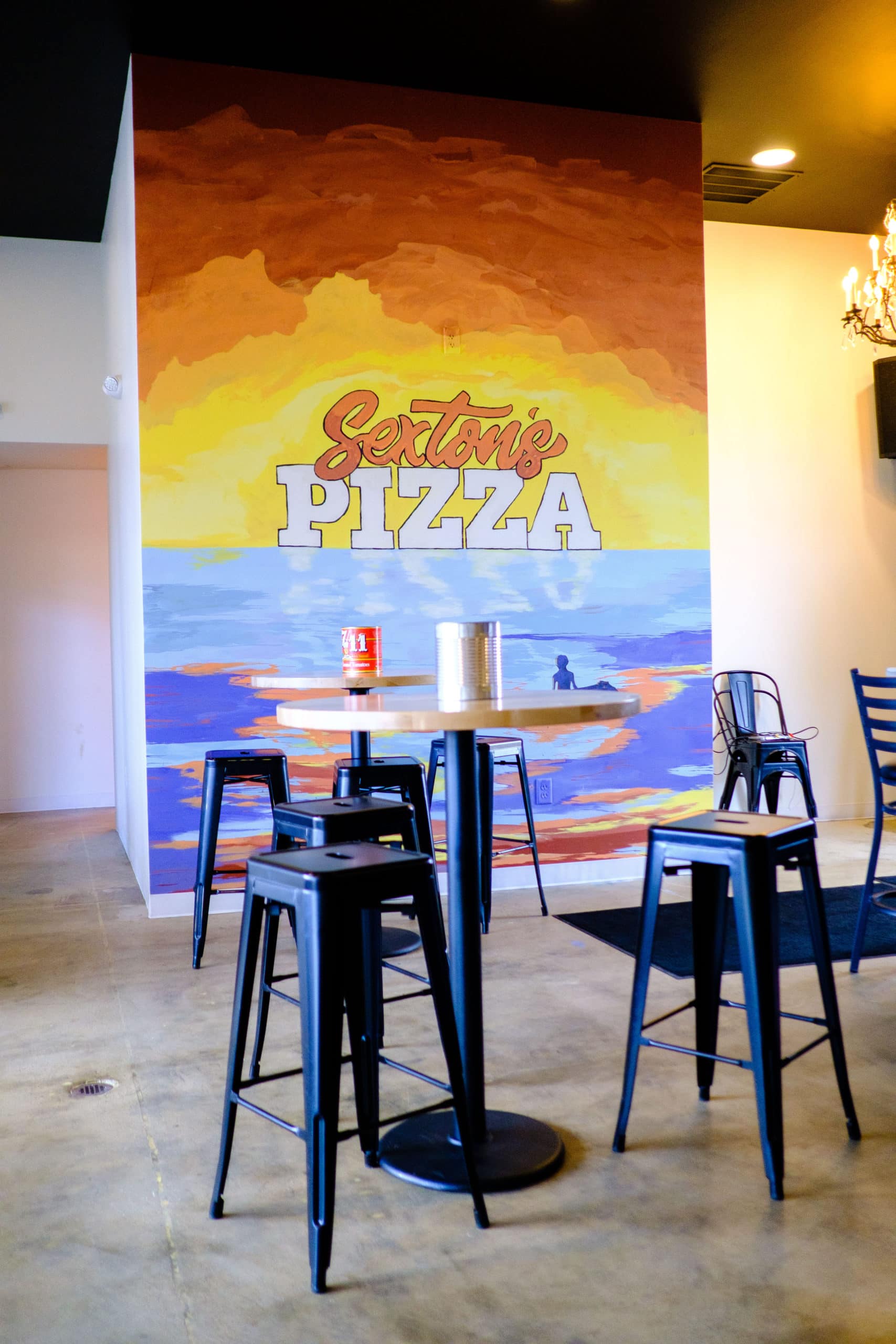 Dining area seating with mural on back wall at Sexton's Pizza in Hilliard, Ohio.