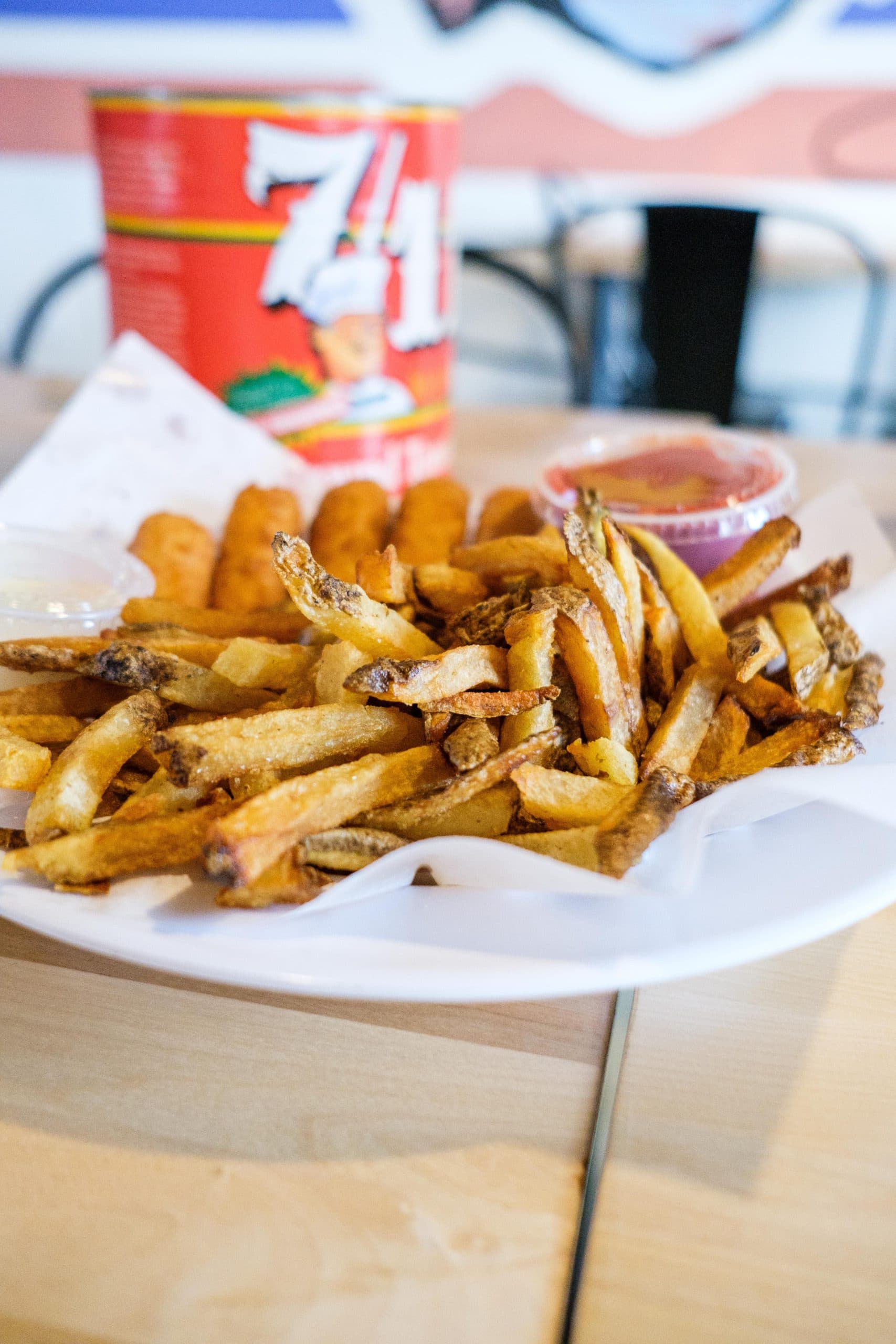 Fresh cut fries on serving plate with fried and breaded mozzarella sticks in the background, at Sexton's Pizza in Hilliard, Ohio.