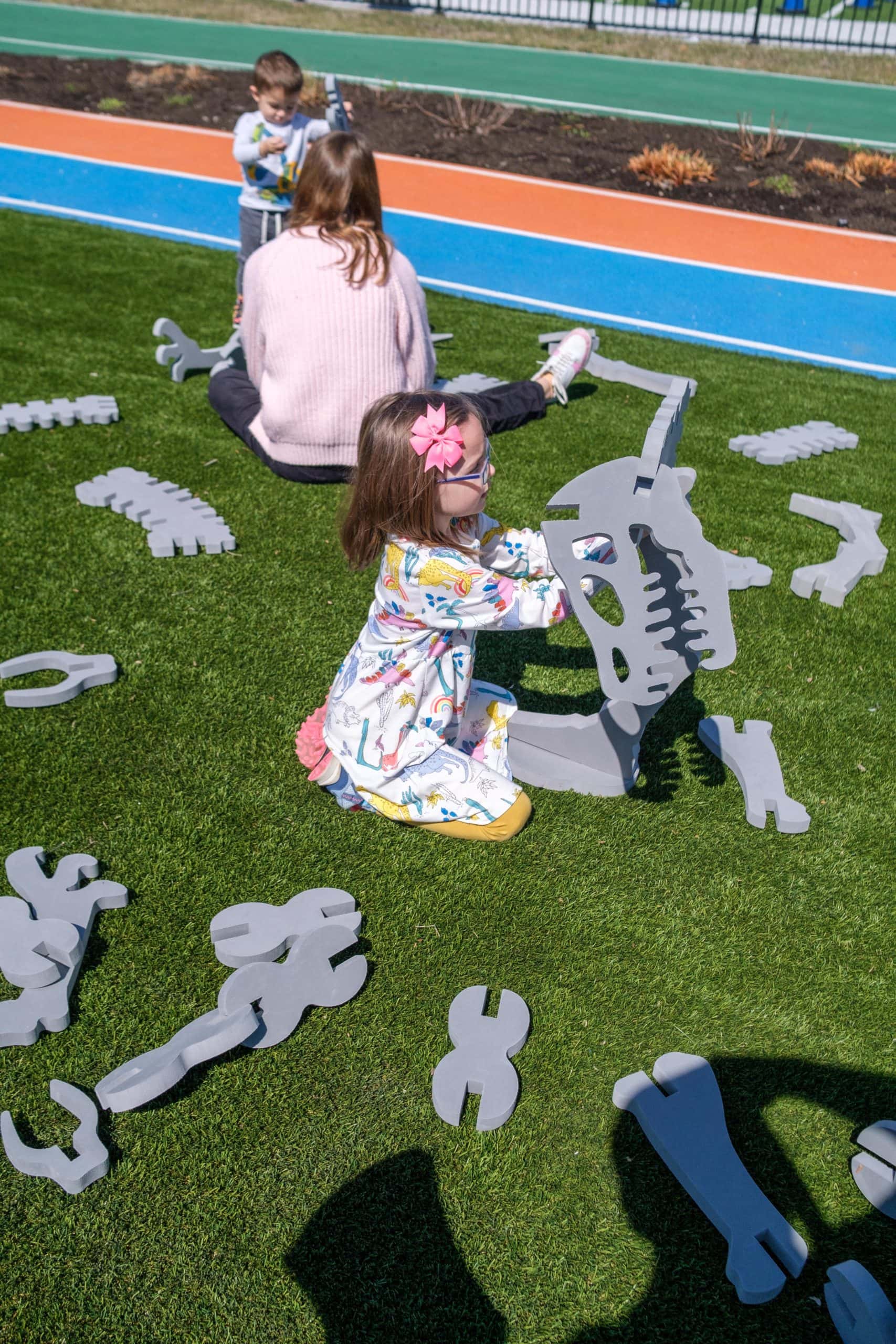 Kids building foam dinosaurs outdoors at the Children's Museum Of Indianapolis.