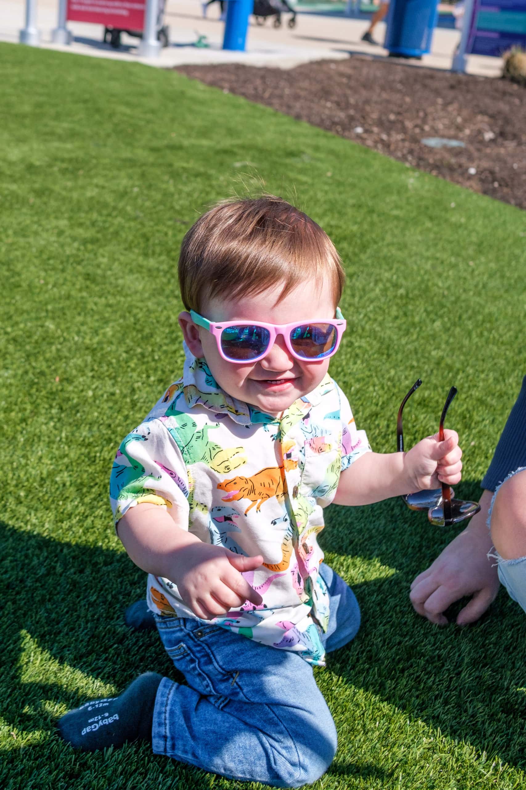 Child enjoying the sun in the outdoor green space at the Children's Museum Of Indianapolis.