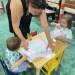 Mom and two kids coloring at The Ohio State Fair.