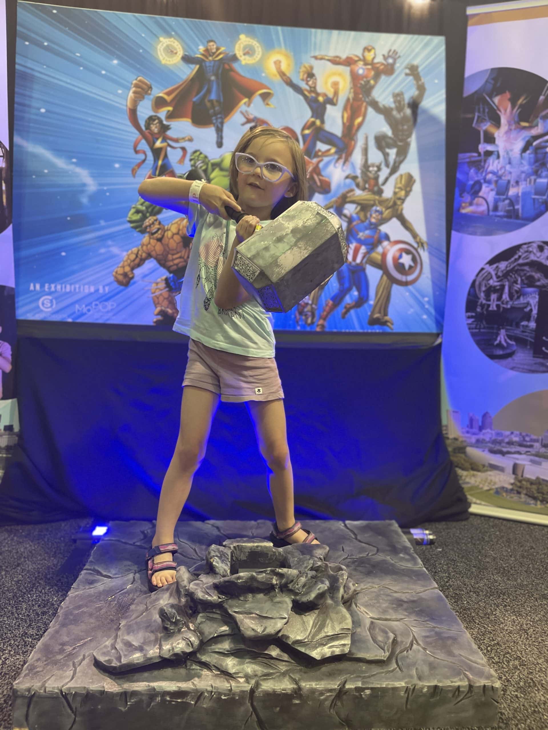 Kid at an interactive exhibit holding Thors Hammer at the State Fair in ohio.