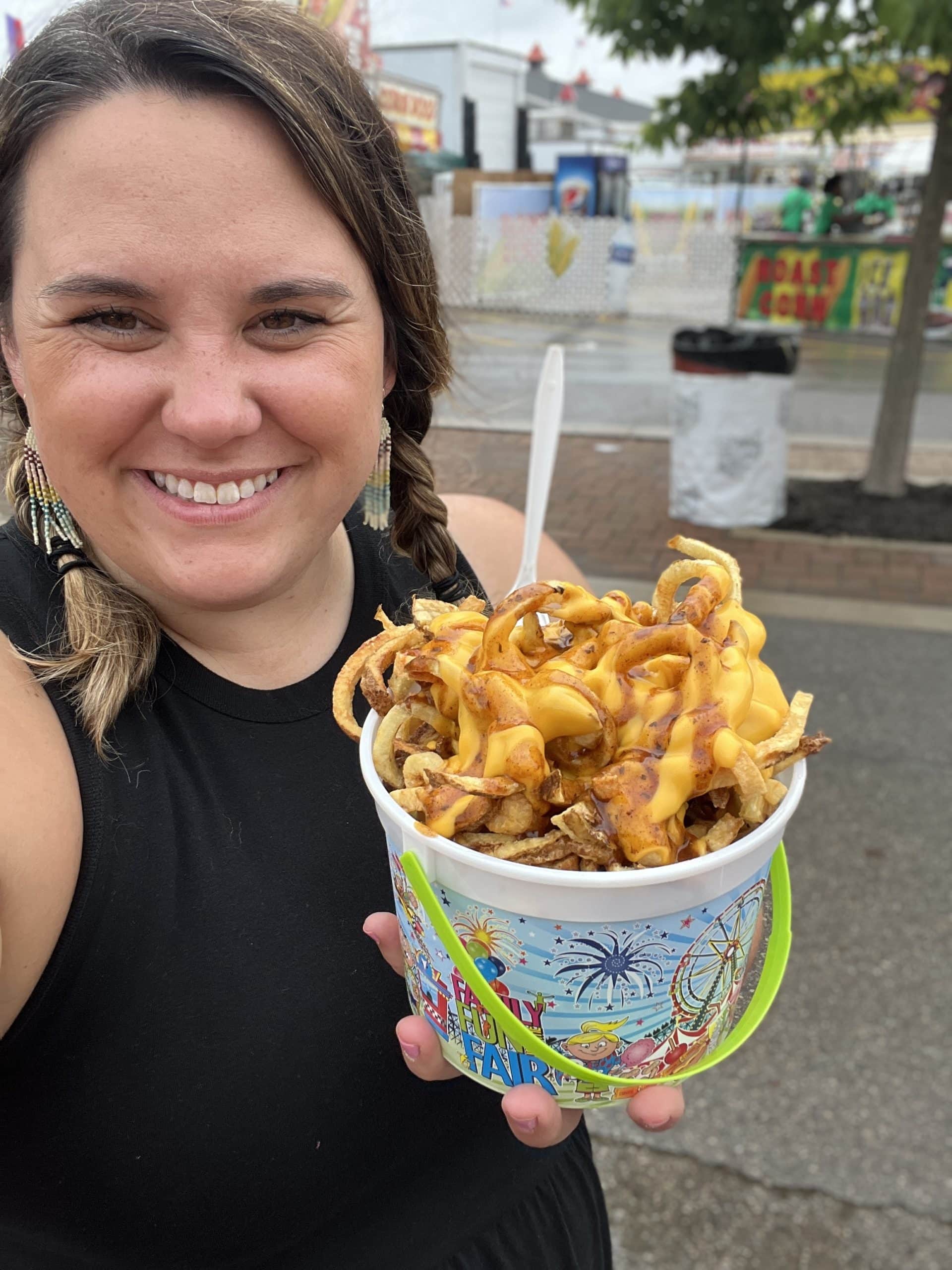woman enjoying cheese fries at the Ohio State Fair.