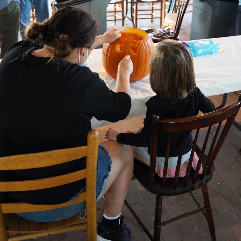 Mother and daughter carving pumpkins at All Hallows' Eve at Ohio Village. 