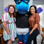 Sisters with Delaware Public Library mascot unicorn in fresh start bakery.