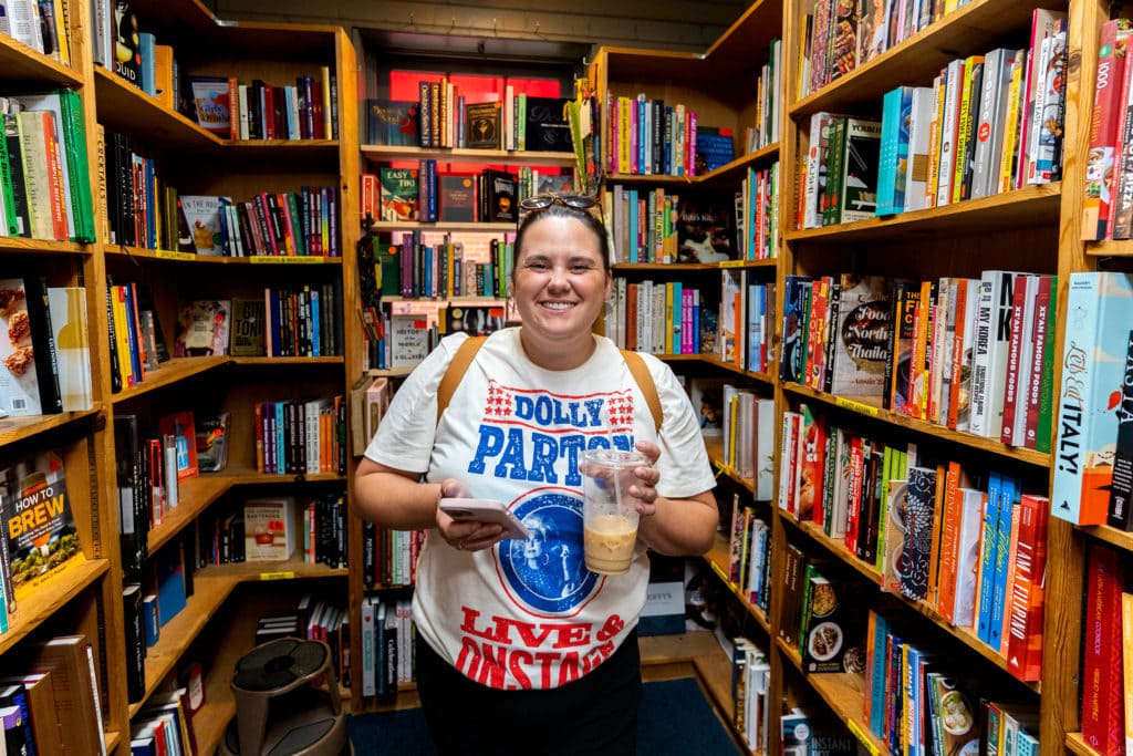 Woman smiling while drinking coffee inside of The Book Loft in German Village.