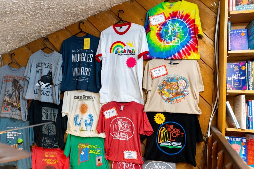 Various T-shirts shown on a wall that are available for purchase at The Book Loft in Columbus, Ohio.