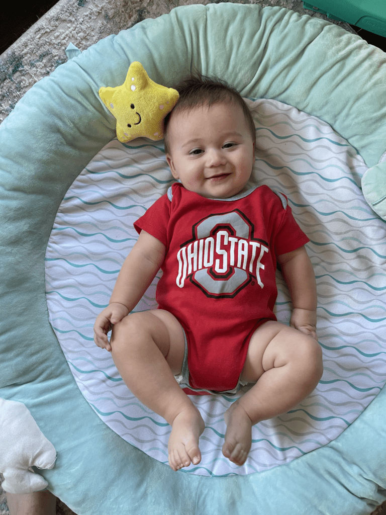 Baby wearing OHIO STATE onesie. 
