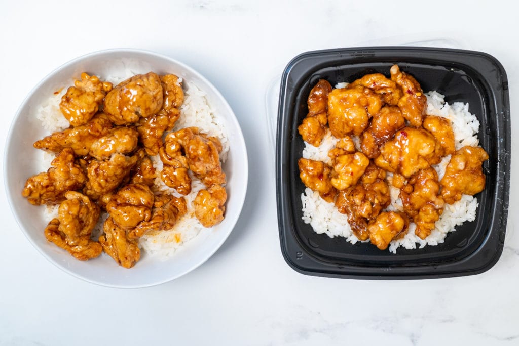 Orange chicken on a white plate next to a black bowl with orange chicken and white rice.